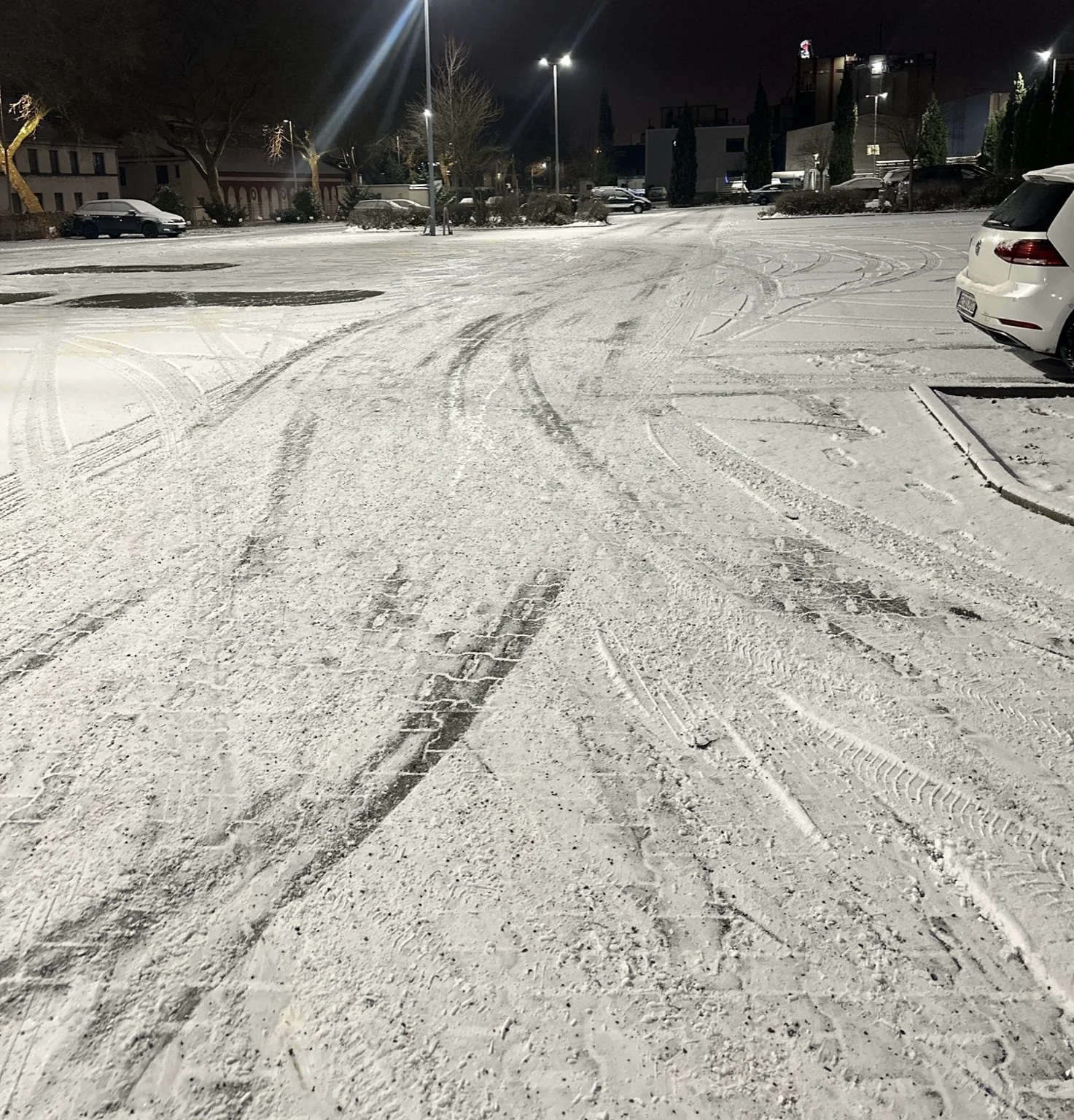 Winterdienst auf verschneitem Parkplatz in Düsseldorf – geräumte Fahrspuren bei Schnee und Eis