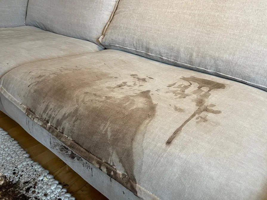 Stark verschmutztes Stoffsofa vor einer professionellen Polsterreinigung in Bottrop mit sichtbaren Flecken und Verunreinigungen.